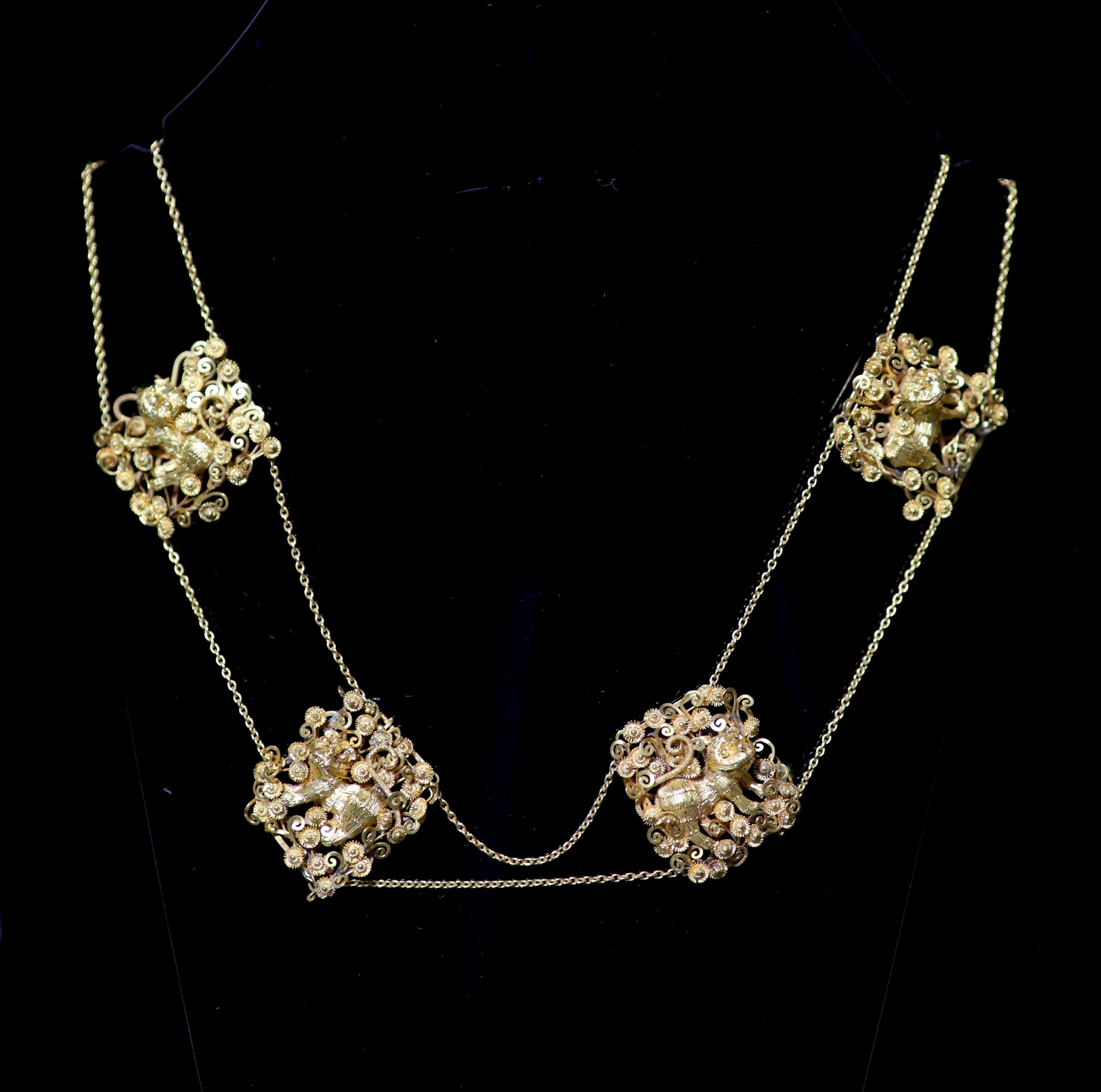 An early 20th century Chinese filigree gold (stamped 20) twin strand necklace with six pierced panels and clasp decorate with Buddhist lions and Phoenixes